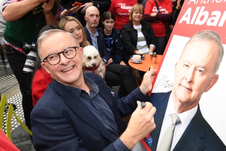 Prime minister-elect Anthony Albanese signs a poster for a young boy as he shares a coffee near his home on 22 May 2022.