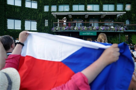 A fan holds up the Czechia flag as Linda Noskova shows off the trophy to fans.