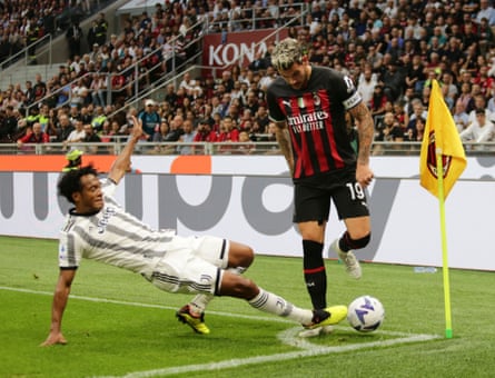 Milan’s Theo Hernández invites a tackle from Juve’s Juan Cuadrado in the corner of the pitch.