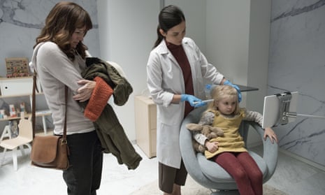 Amother (Rosemarie Dewitt) watches as a surveillance chip is inserted into her daughter (Aniya Hodge) in the Jodie Foster-directed Black Mirror episode Arkangel