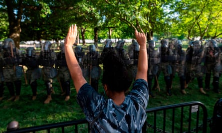 A protester raises her hands near a line of National Guard soldiers, near the White House on Monday.