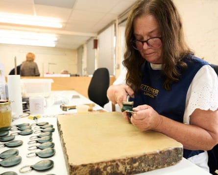 A worker at the Ettinger factory carefully stitches a leather keyring fob