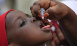 A health official administers a polio vaccine to a child in Nigeria. Nigeria saw its last case of polio in 2014.