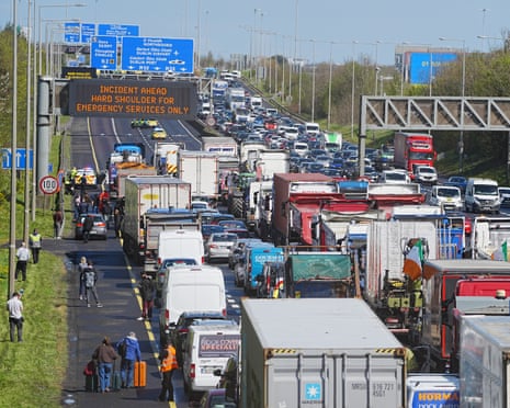 People with their luggage walk past the heavy traffic on Dublin's M50 Northbound, due to vehicles taking part on the third day of a National Fuel Protest against rising fuel prices, Thursday April 9, 2026