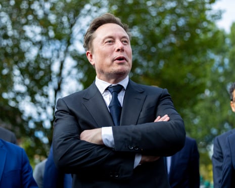 Elon Musk speaks with his arms crossed