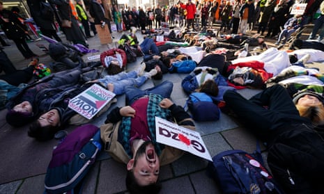 Protesters lie on the ground in Glasgow, holding signs calling for a ceasefire.