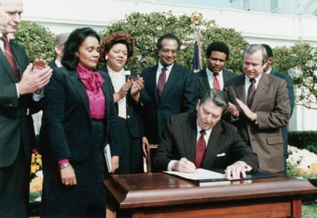 reagan signs bill surrounded by people