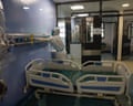 a nurse in protective gear works in a hospital room