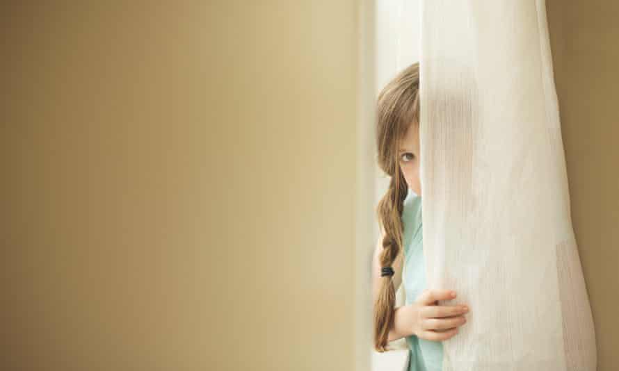 Shy girl peeking around curtain