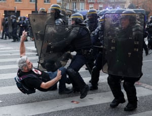 French Republican Security Corps police officers clash with a protestor during a demonstration, a week after the government pushed a pensions reform through parliament without a vote, using the article 49.3 of the constitution, in Toulouse