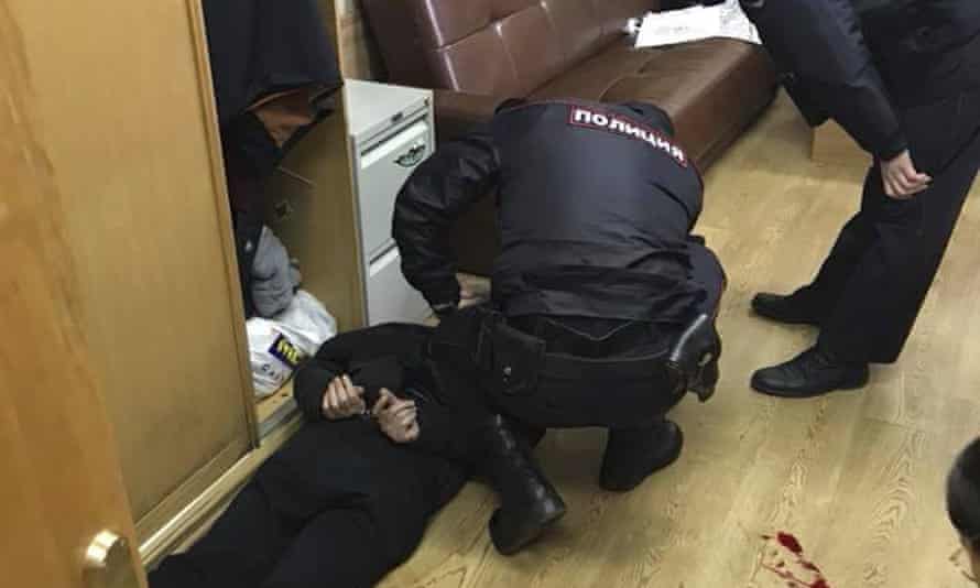 Police officers detain a man after Tatyana Felgenhauer was stabbed at the offices of Ekho Moskvy.