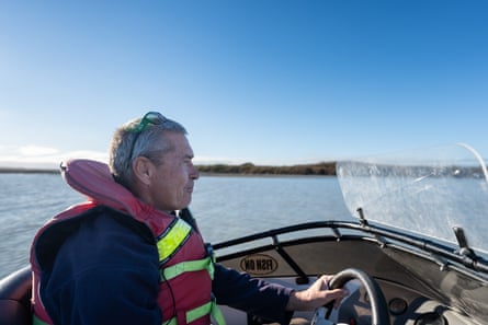A man driving a boat on a river