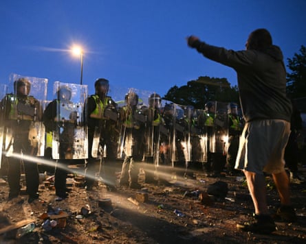 A protester confronts a line of riot police