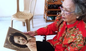 Trinh Thi Ngo photographed in 2015 at her Ho Chi Minh City home with a portrait of her younger self.