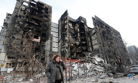 Nurse Svetlana Savchenko stands next to the destroyed building where her apartment was located in Mariupol.