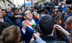 Jean-Luc Mélenchon on the street surrounded by reporters.