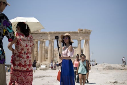 A tourist takes a selfie in front of the Parthenon temple in Athens. All Greek archaeological sites will shut during the hottest hours of the day this week.