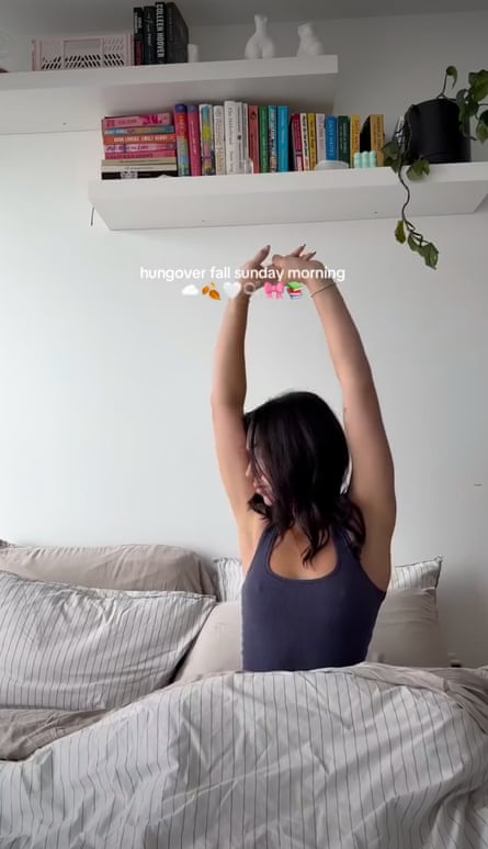 A young woman stretches in bed, alongside the caption ‘hungover fall sunday morning’