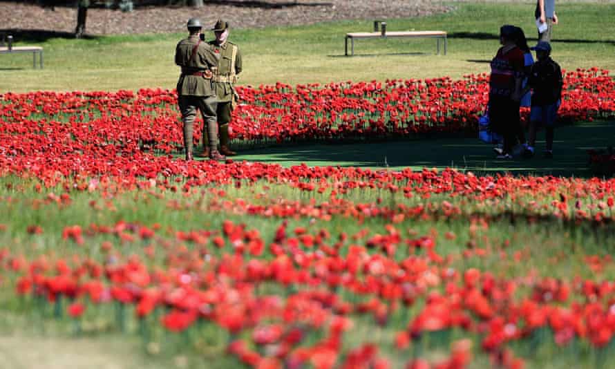 Soldiers stand amoungst a field of fabric poppies ahead of the Remembrance Day Service at the Australian War Memorial on November 11, 2018 in Canberra.