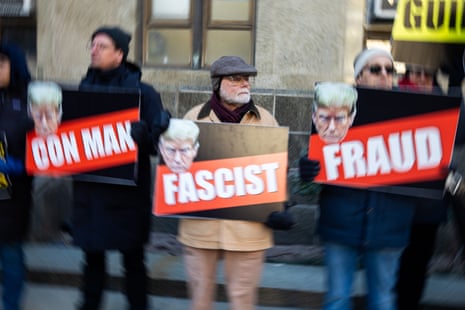 three people with signs that say con man fascist and fraud