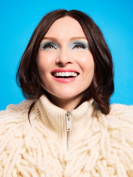 A head-and-shoulders shot of Sophie Ellis-Bextor wearing a cream, fluffy knit zip-up cardigan with a high-neck ribbed collar