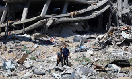 people walk among destroyed buildings