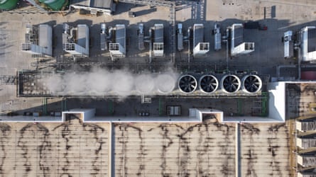 An aerial shot of steam billowing from vents running alongside a section of concrete roof.