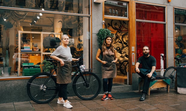 Portrait of female and male coworkers outside bicycle shop