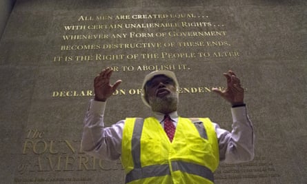 Museum director Lonnie Bunch stands in front of one of the museum’s engraved walls.