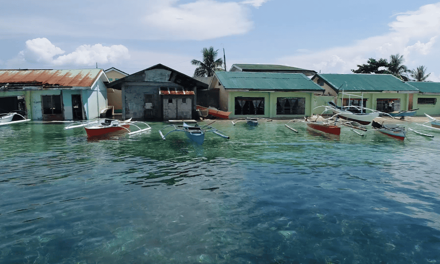 On Bilangbilangan island homes are inundated, gardens submerged, and schoolchildren sit in classrooms ankle-deep in water.
