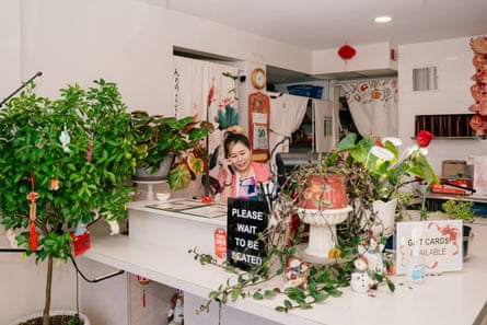 A woman on the phone behind her restaurant counter