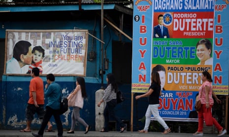 People walking past Duterte ads in Davao City, the Philippines