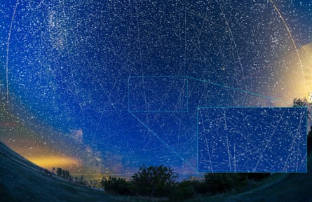 A blue night sky with hundreds of satellites seen as white dots