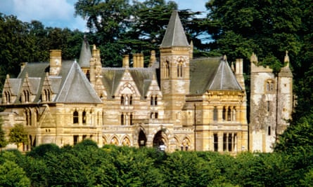 A far away photograph of the front of Ettingon Park, a gothic manor with turrets and yellow limestone bands. 