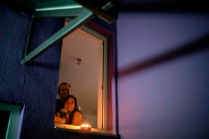Maria, her partner and their dog watch a projected movie