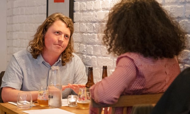 Dining across the divide: ‘He supports a new Heathrow runway – we should invest in trains’ 3 Jasper and Miles sitting at a restaurant table against a white-painted brick wall