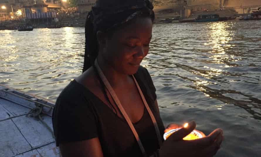 Ella Paradis holding a candle by the river in Varanasi