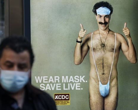 US-ENTERTAINMENT-FILM-HEALTH-VIRUS<br>A person wearing a mask walks past a bus stop ad on 5th Avenue, October 15, 2020, for the upcoming movie “Borat 2,” featuring actor Sacha Baron Cohen, ahead of its release on October 23. - The poster gives reference to the Covid-19 pandemic by replacing Borats iconic green mankini with a face mask. (Photo by TIMOTHY A. CLARY / AFP) (Photo by TIMOTHY A. CLARY/AFP via Getty Images)