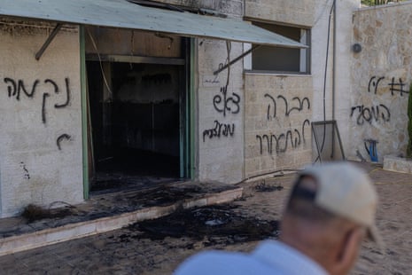 A man walks past the damaged mosque with graffiti-scrawled wallss