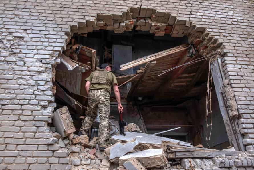 A soldier enters in the hole of building recently bombed to inspect the damage in Malinovka, a village east of Zaporizhia.