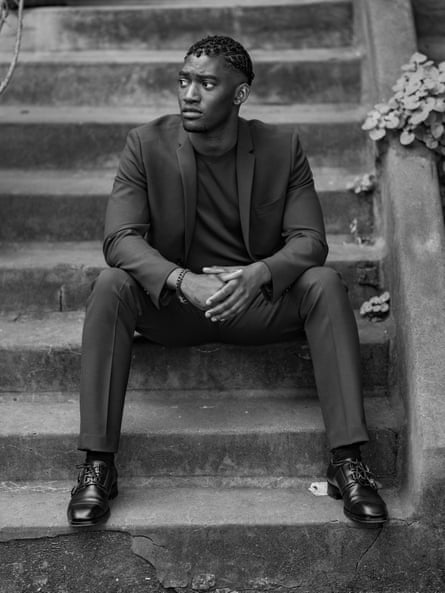 Malachi Kirby, who plays Darcus Howe, sitting on some steps.