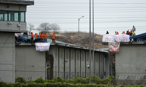 Men imprisoned at the Guayaquil prison hold banners reading ‘We want peace,’ and ‘Peace, no to violence’ after the riots erupted there. 