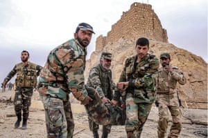 Syrian government army soldiers assist a fellow soldier who was injured in an explosion near Fakhr al-Din al-Maani Citadel