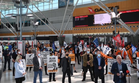 People stand in a Qantas terminal during a protest