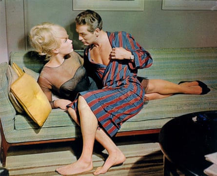 Paul Newman in a striped robe leans close to Elke Sommer on a sofa in The Prize