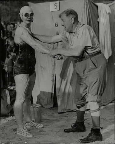 Brenda Fisher being smeared in grease by her trainer, Herbert McNally, in preparation for her 1951 race in the English Channel - as she climbed ashore after her record swim she asked 