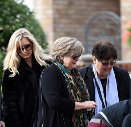 They stand outside the church alongside a third woman