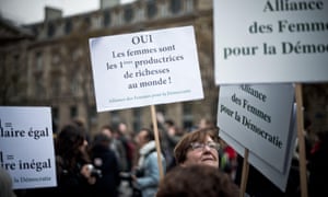 A woman holds a sign at the wage equality for woman rally in Paris on Monday.
