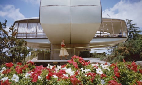 An unidentified woman in a yellow dress stands under the House of the Future attraction, conceived jointly by architects at MIT (Massachusetts Institute of Technology), the Monsanto Chemical Company, and the Walt Disney Imagineering team, and exhibited at Disneyland, Anaheim, California, from 1957 to 1967. 
