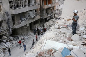 A member of the Syrian civil defence volunteers, known as the White Helmets, stands on the rubble of destroyed buildings during a rescue operation following an airstrike on the rebel-held neighbourhood of Bustan al-Basha 